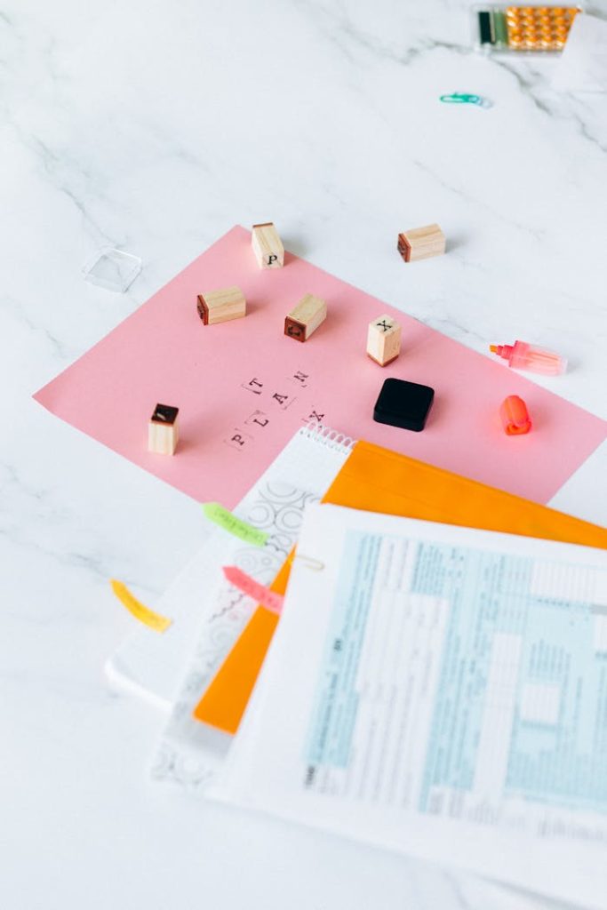 Tax forms and rubber letter stamps on a marble desk.